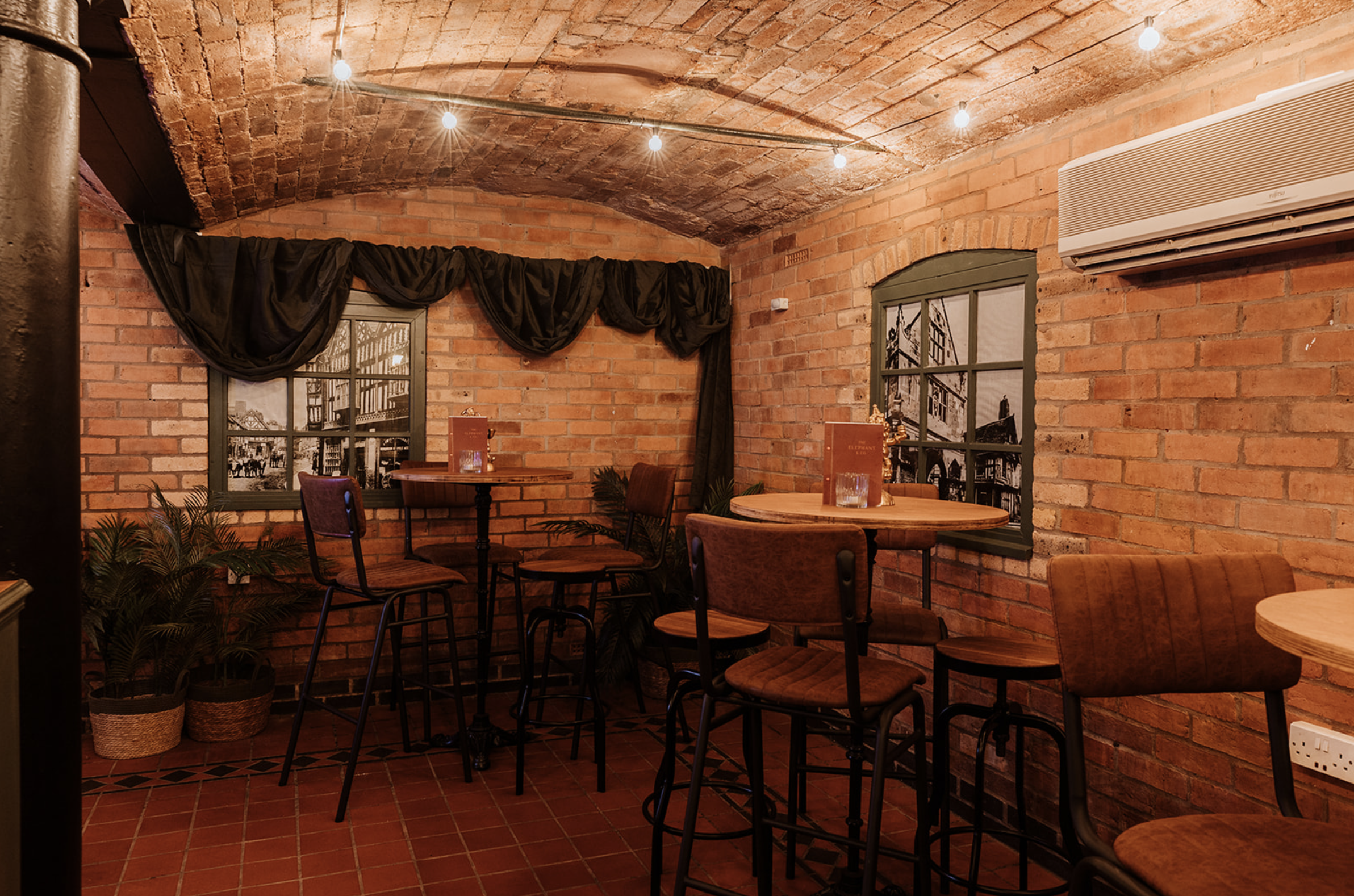 High tables beneath draped curtain pelmets and heritage photograph windows