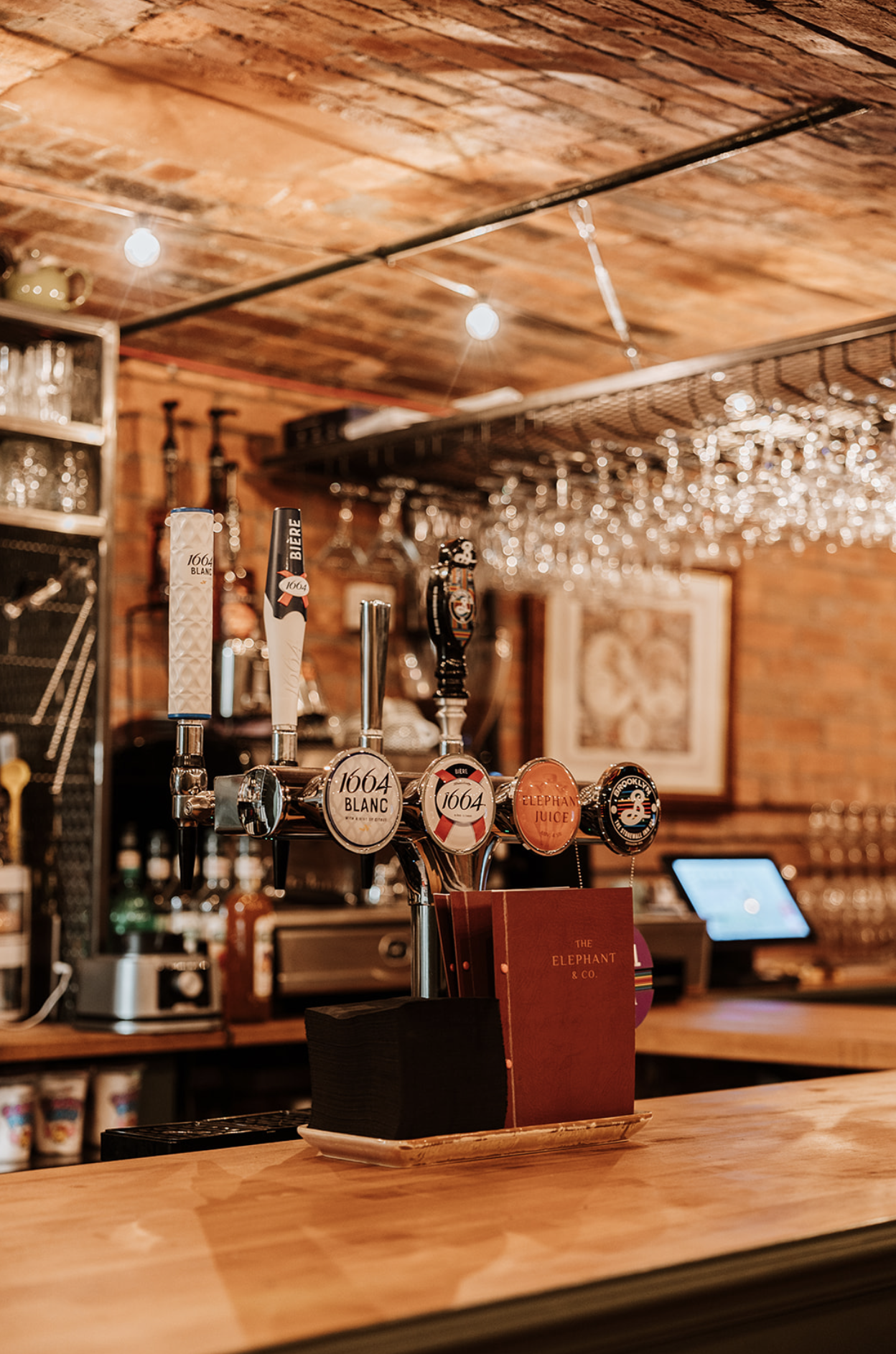 Beer taps on the bar top with the menu in a tray, chosen to sit with the room
