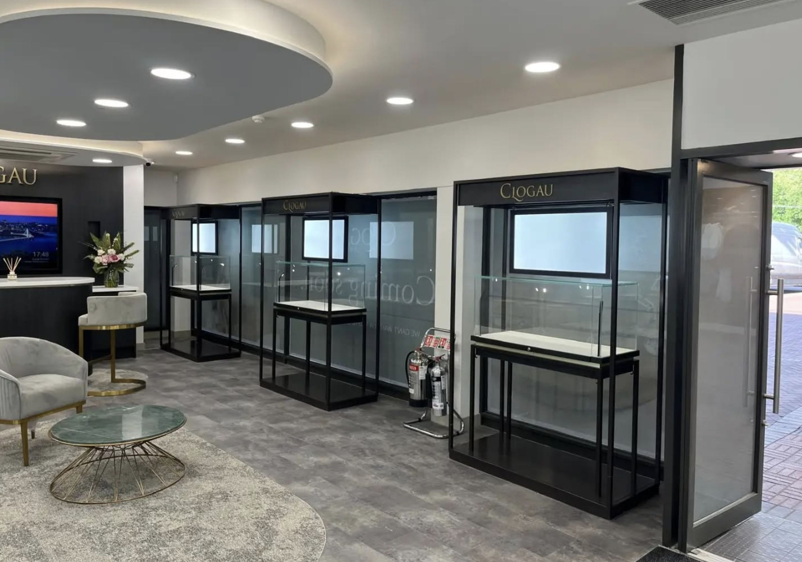 Clogau entrance zone with freestanding branded display cabinets stepping back from the door towards the seating area