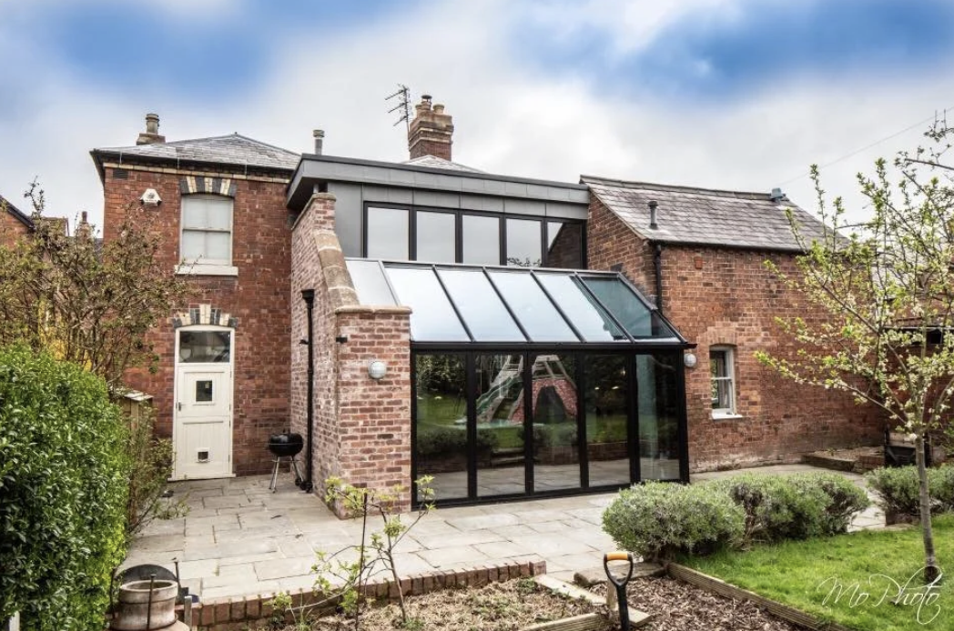 The completed rear of Oakleigh House: a glazed lean-to and zinc-clad first floor between the original brick house and outbuilding