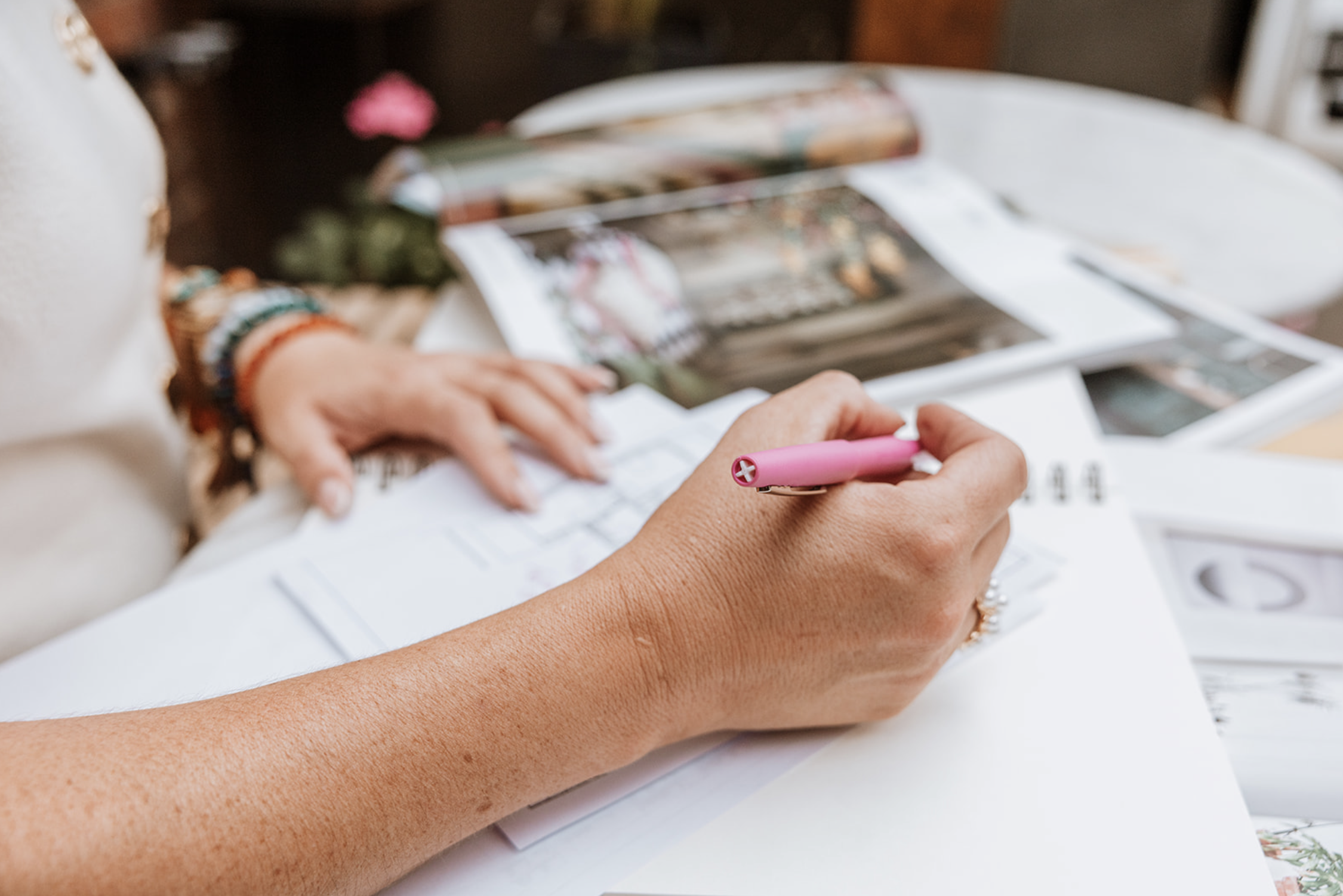 Camilla Monk reviewing a plan, pen in hand, with reference material to one side