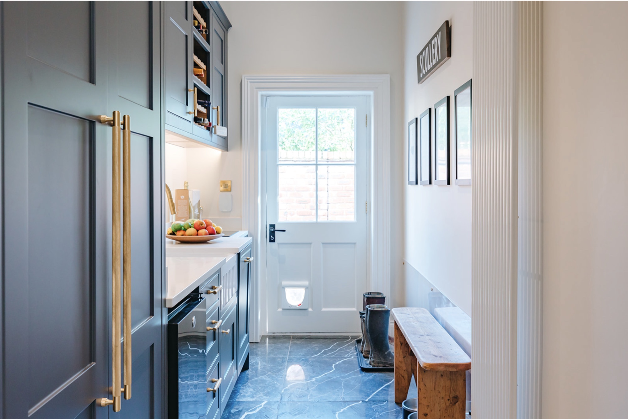 Scullery passage with teal cabinetry, boot bench, back door and a polished dark veined floor