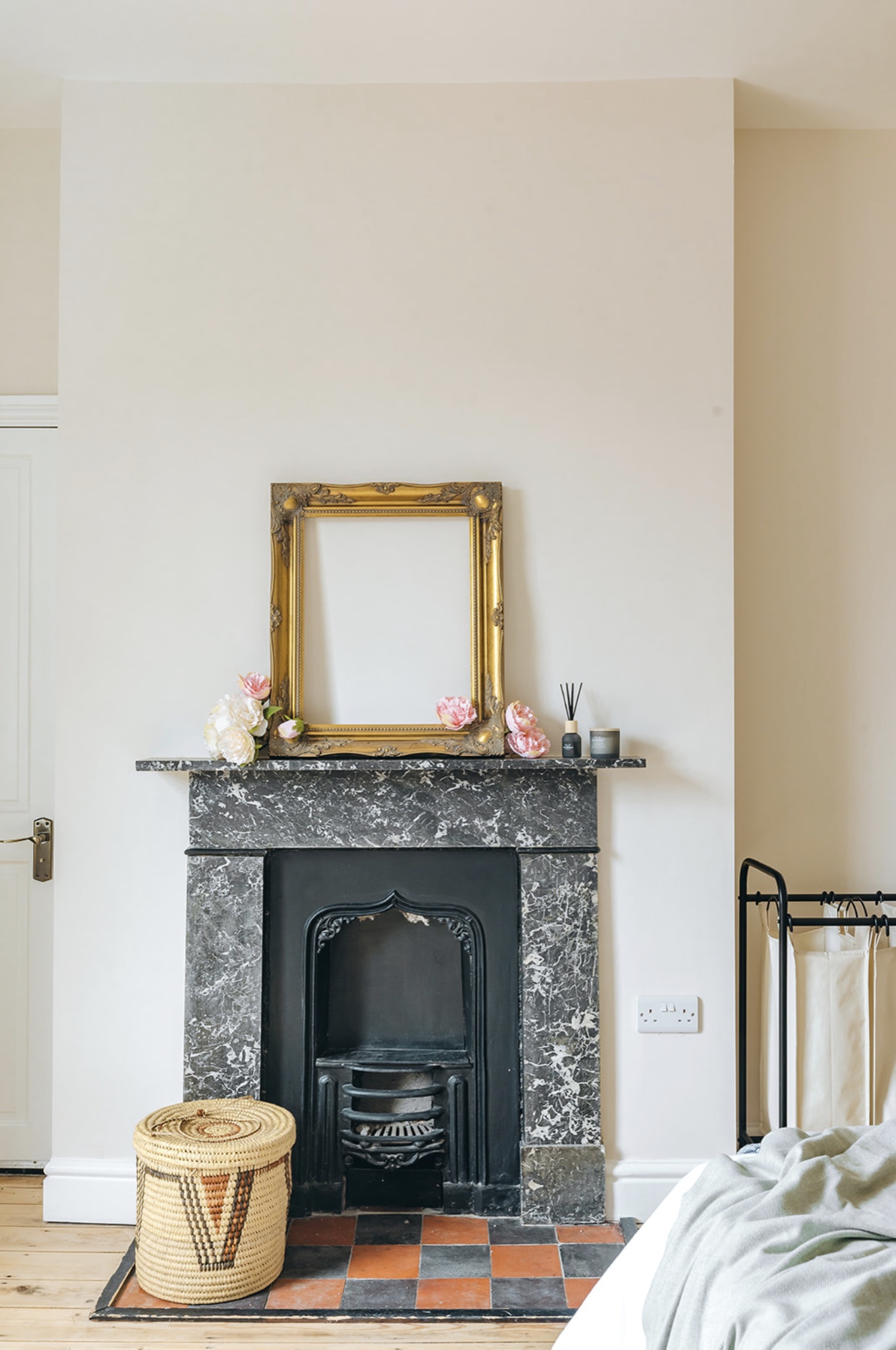 Original grey marble and black cast-iron bedroom fireplace with a gilt mirror and quarry-tiled hearth
