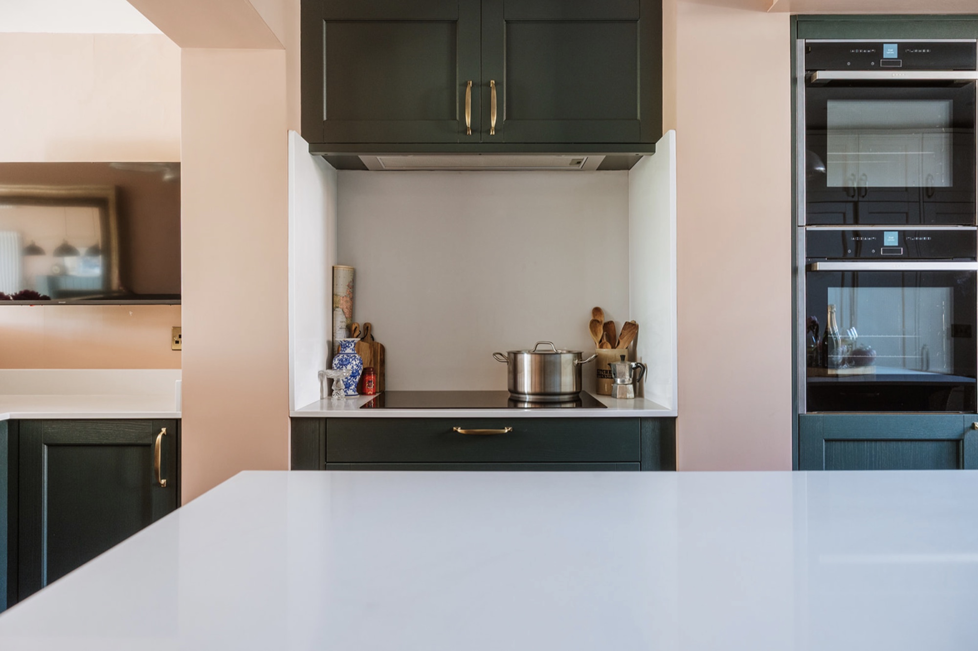 Deep green kitchen cabinetry framing the cooking area at Oak Street