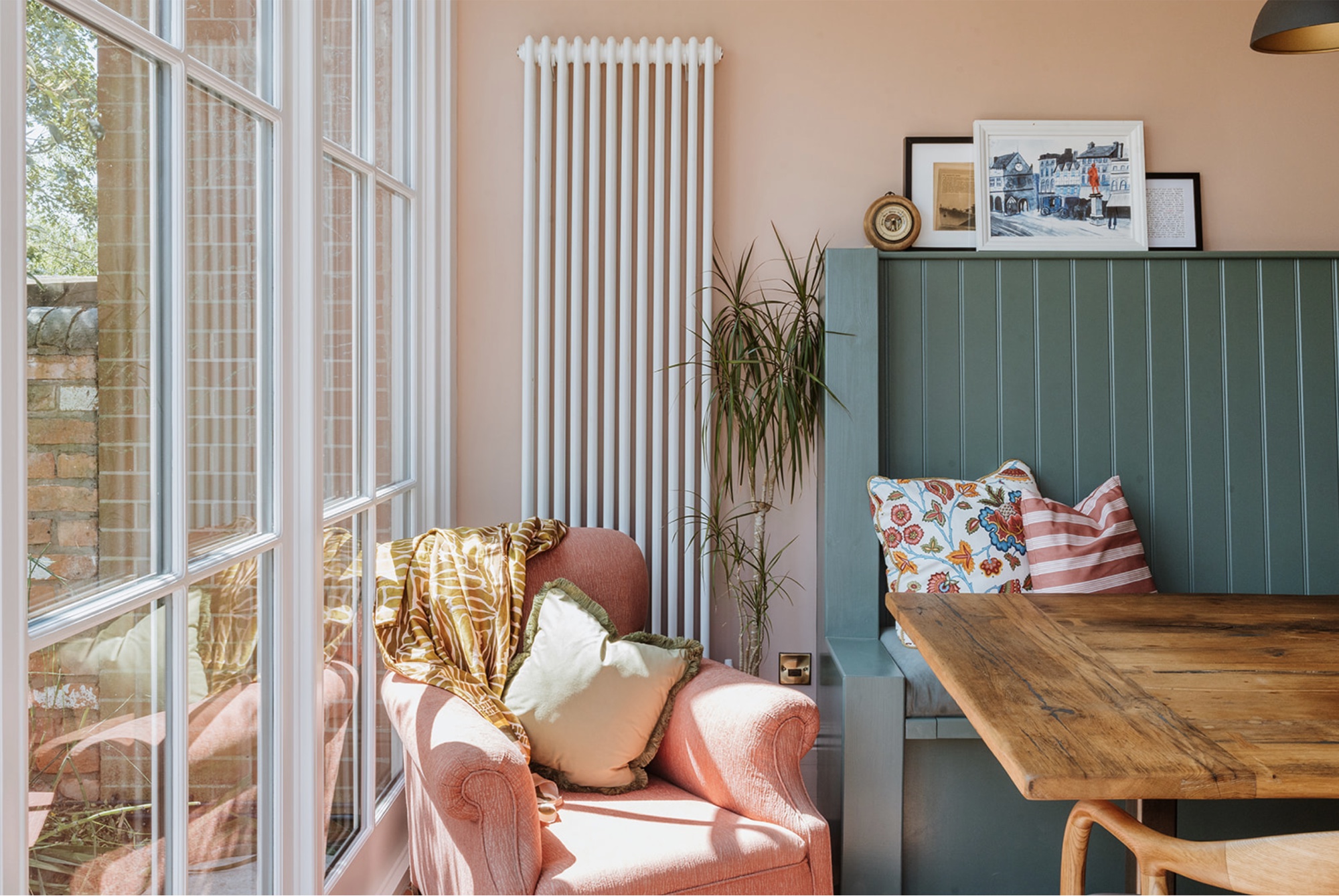 Coral armchair and green banquette beside the Oak Street garden doors