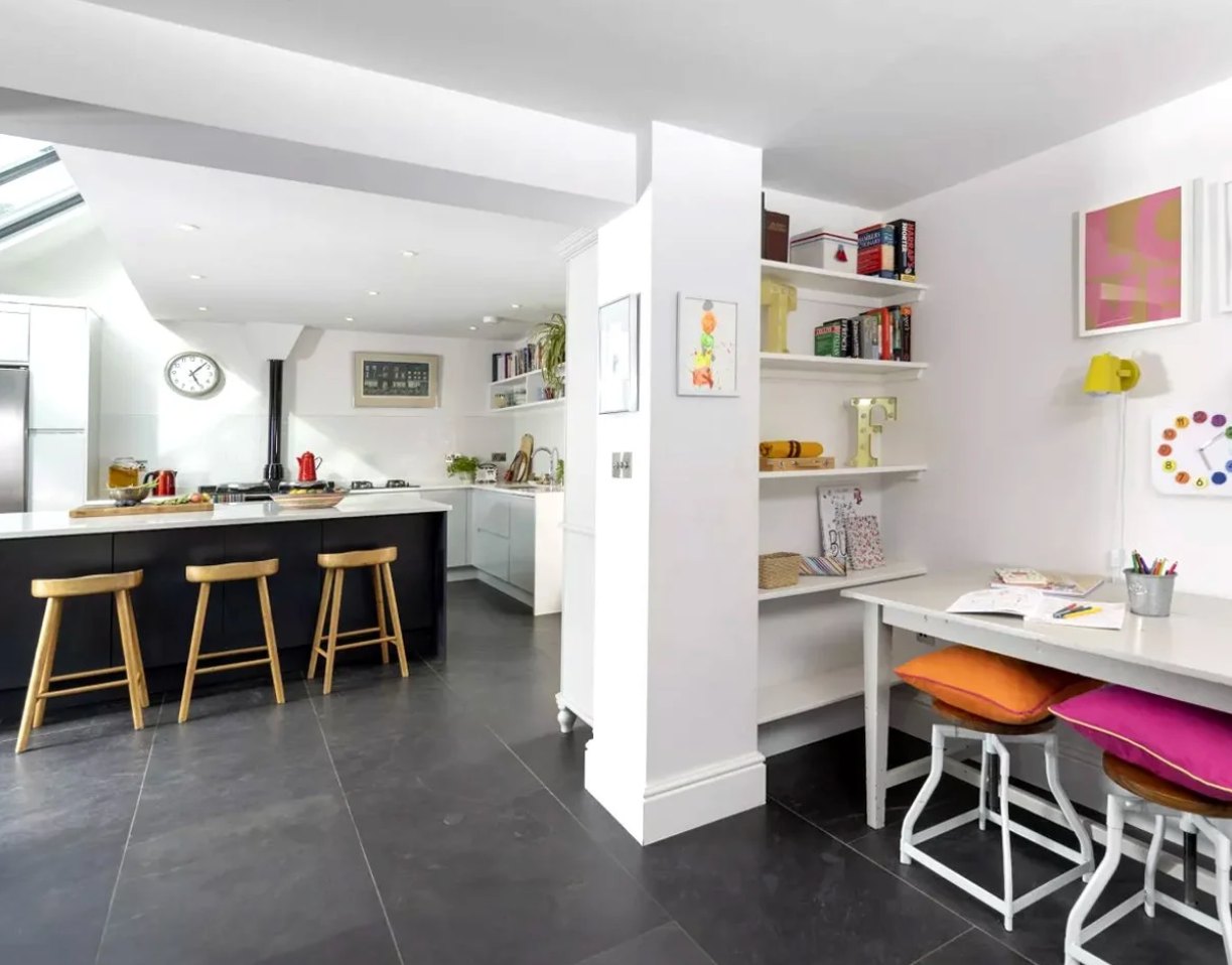 View back through the Oakleigh House kitchen to a built-in homework desk and shelving beside the island