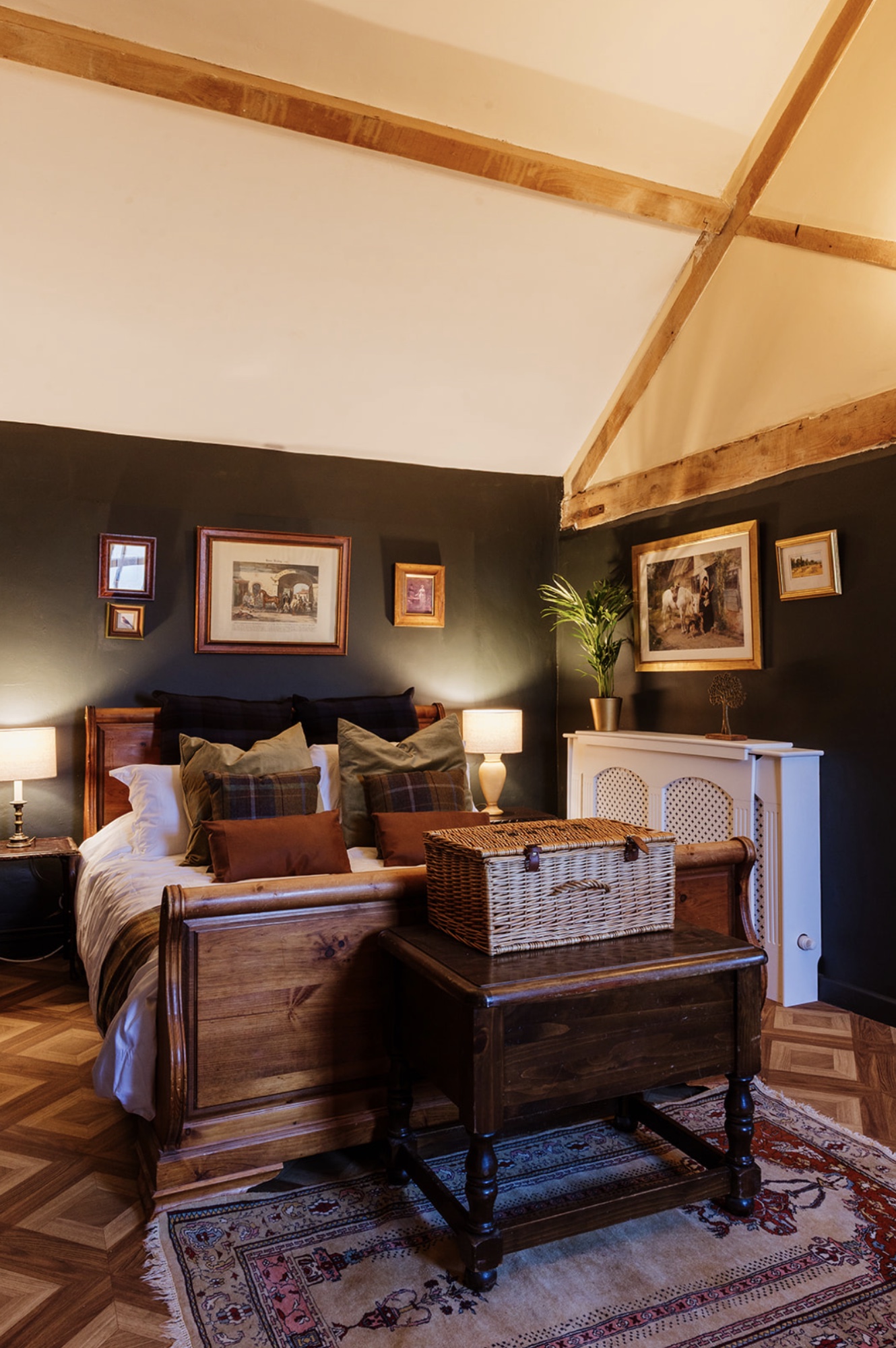 Pool House bedroom with a timber sleigh bed, wicker chest and patterned rug