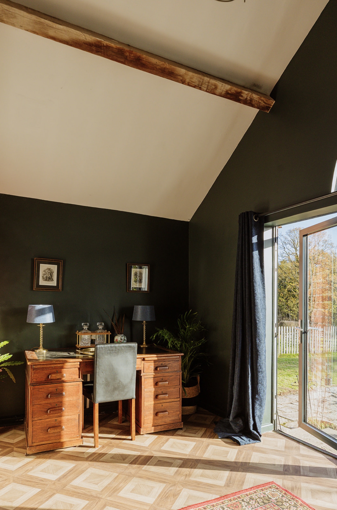 Writing desk in the Pool House beside open glazed doors leading to the garden