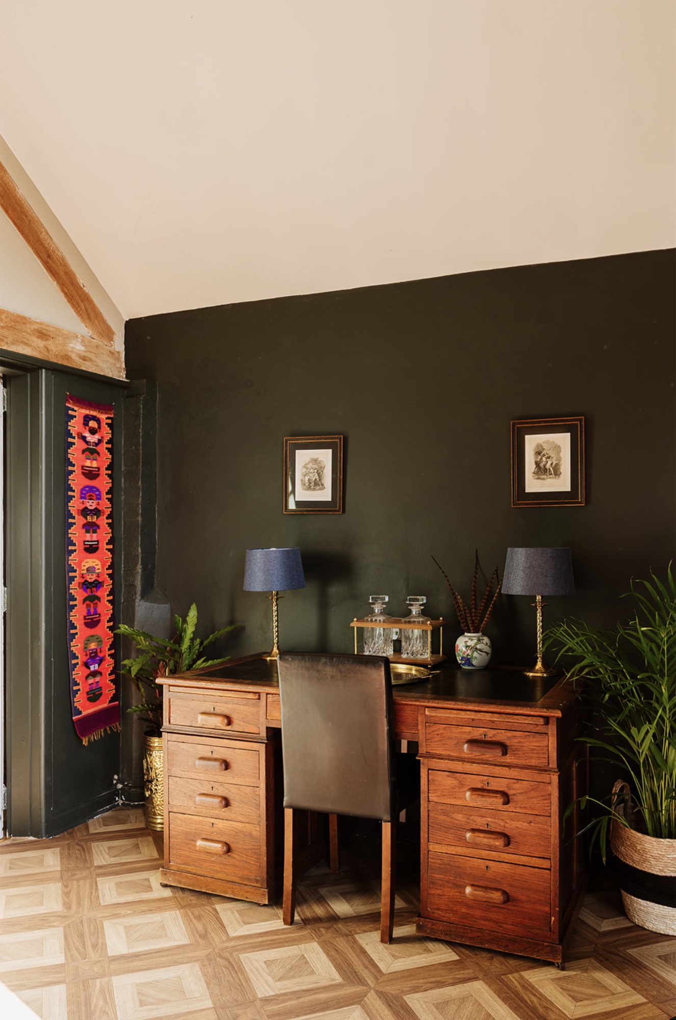 Antique writing desk styled against a deep green wall in the Pool House